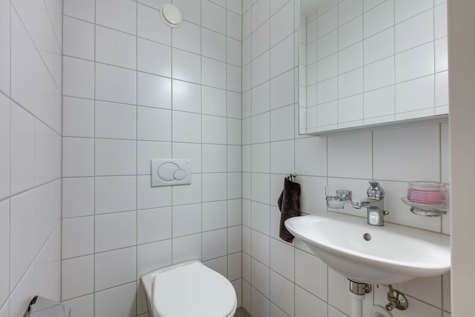 Kleines weiß gefliestes Gäste-WC