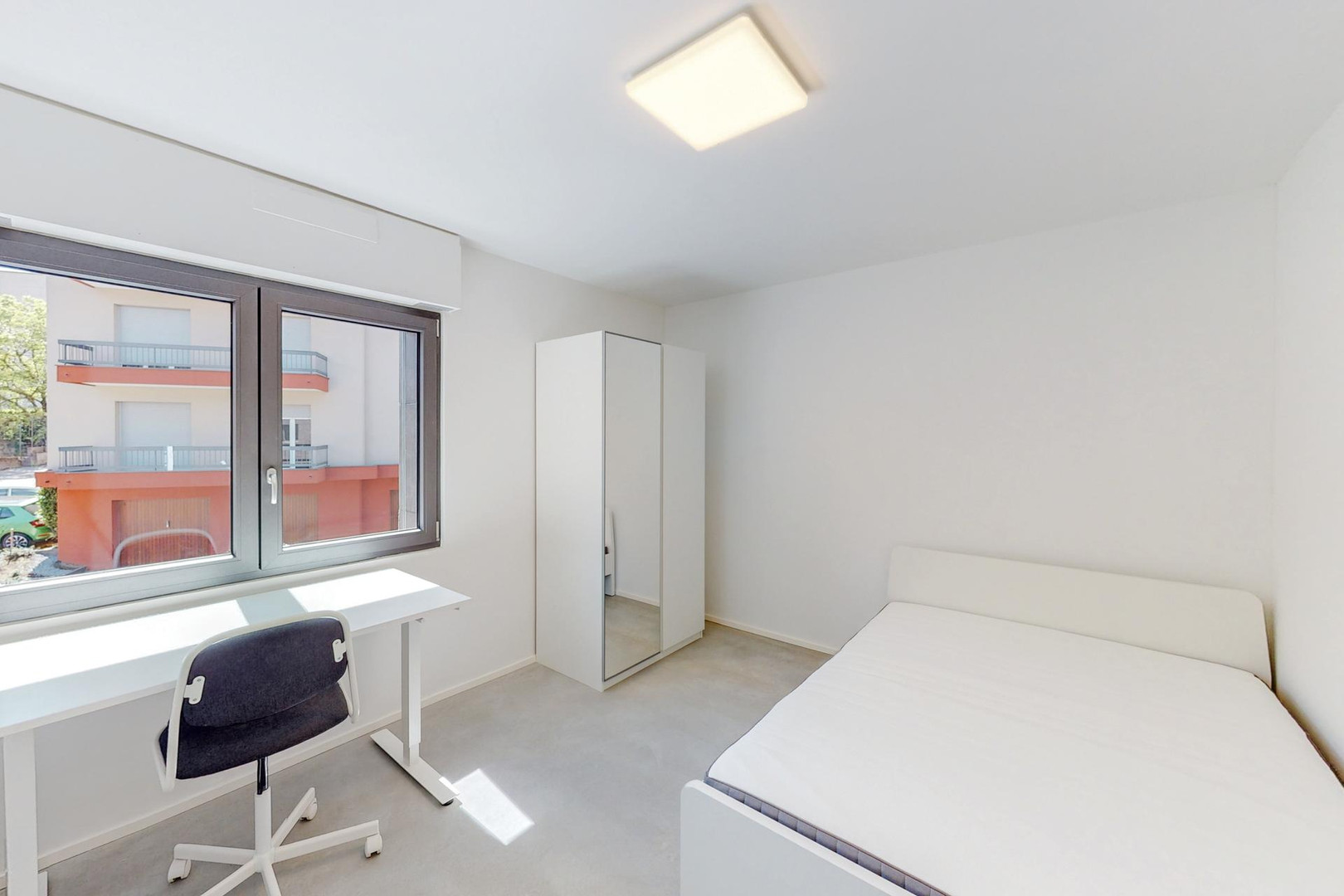 Helles, schlichtes Schlafzimmer mit Schreibtisch
