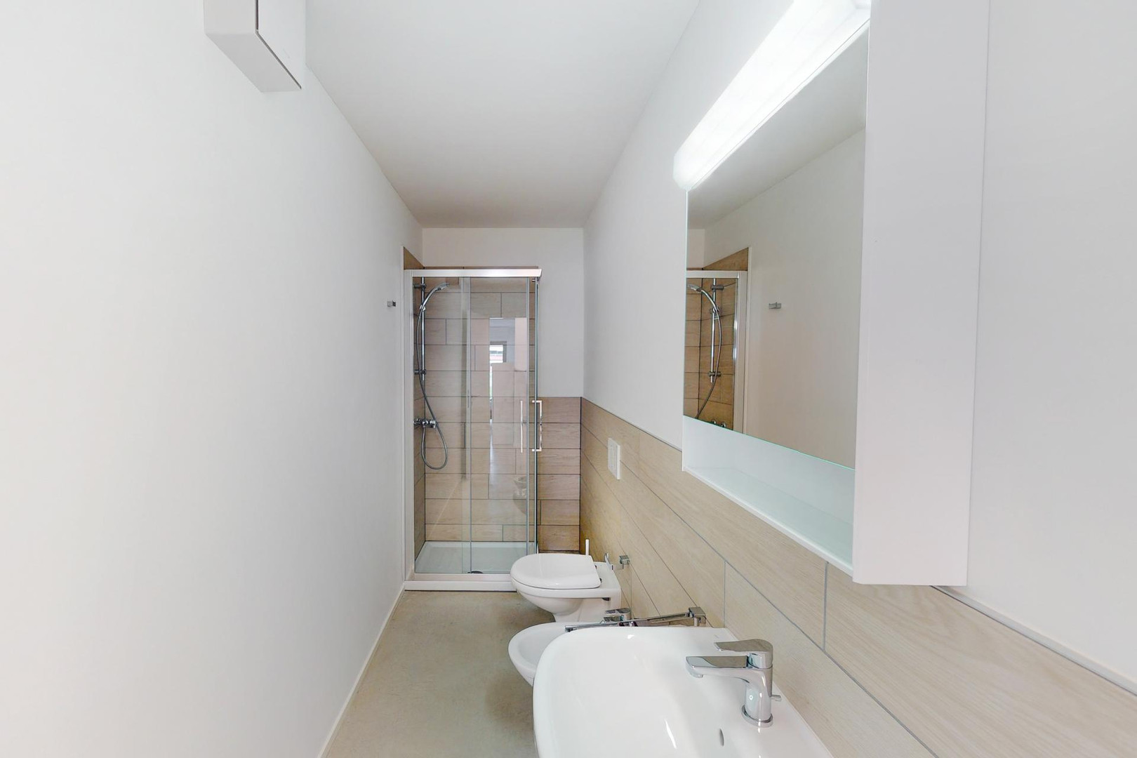 Schmaler, modernes Badezimmer mit Dusche, WC und Doppelwaschbecken
