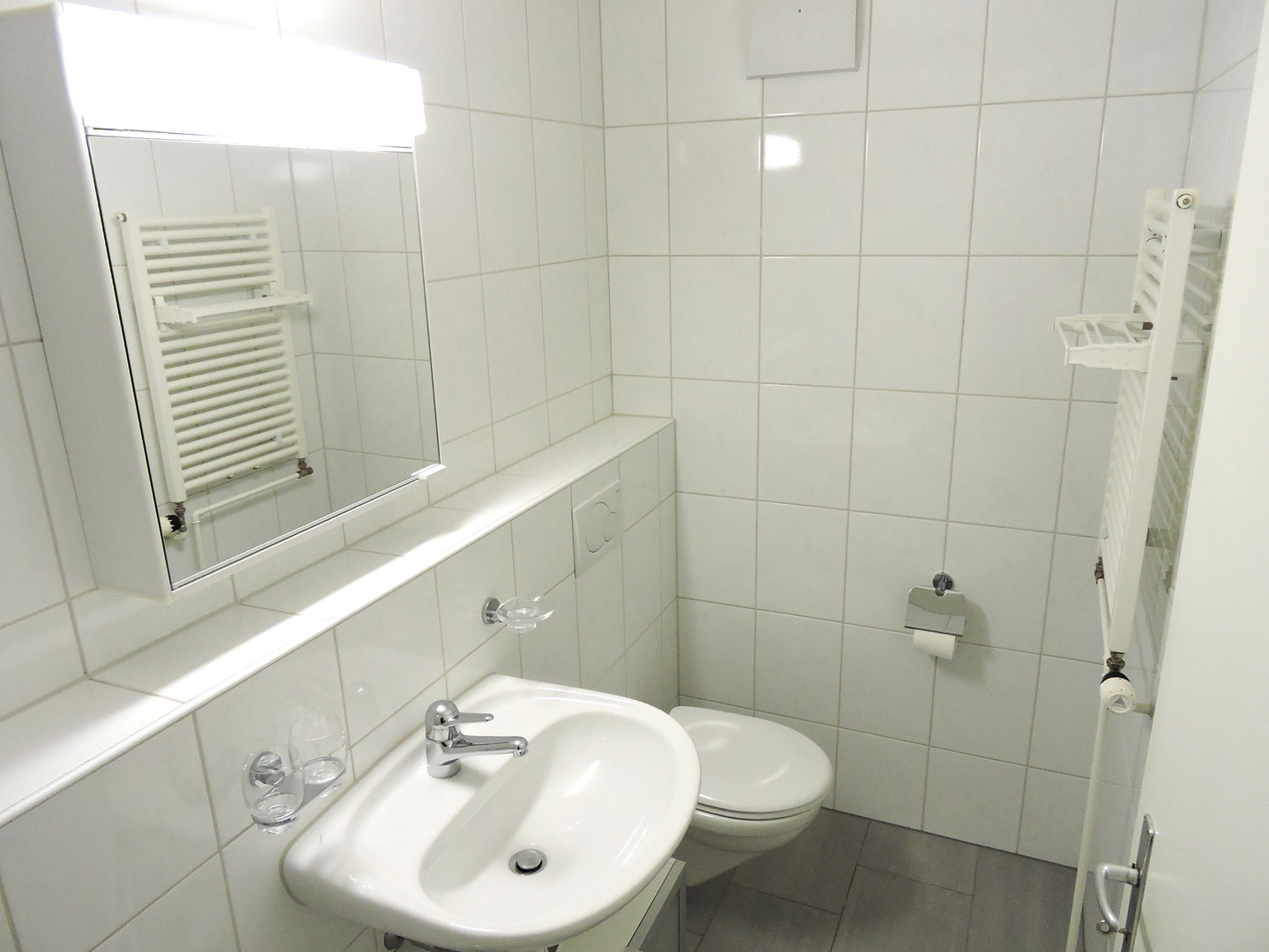 Kleines weiß gefliestes Bad