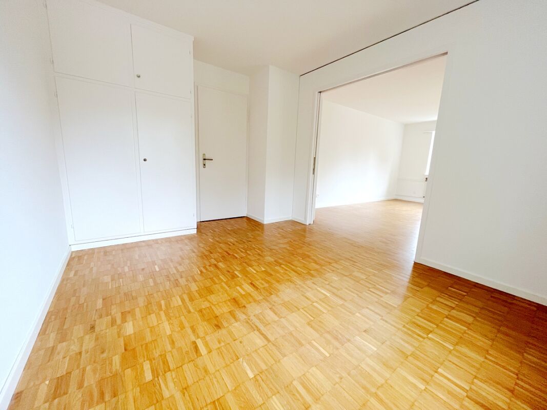 Helles leeres Zimmer mit Parkettboden und Einbauschrank