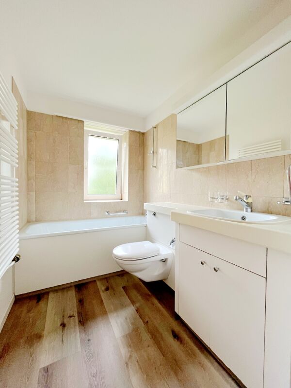 Helles Badezimmer mit Wanne und Waschtisch