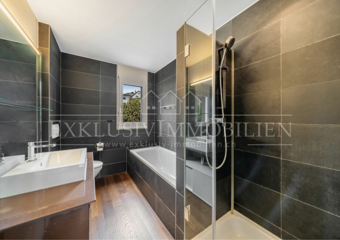 Modernes Badezimmer mit Badewanne und Glasduschabtrennung