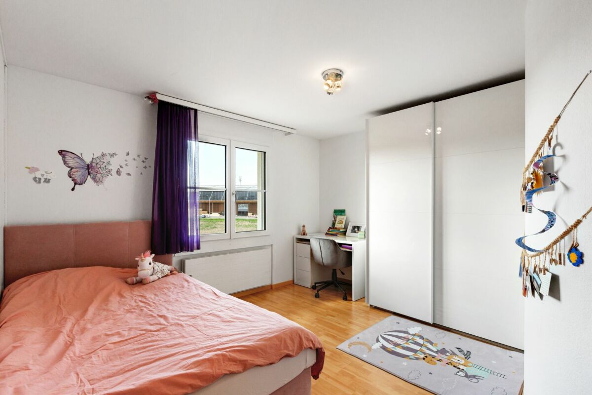 Kinderzimmer mit Bett, Schreibtisch und großem Einbauschrank
