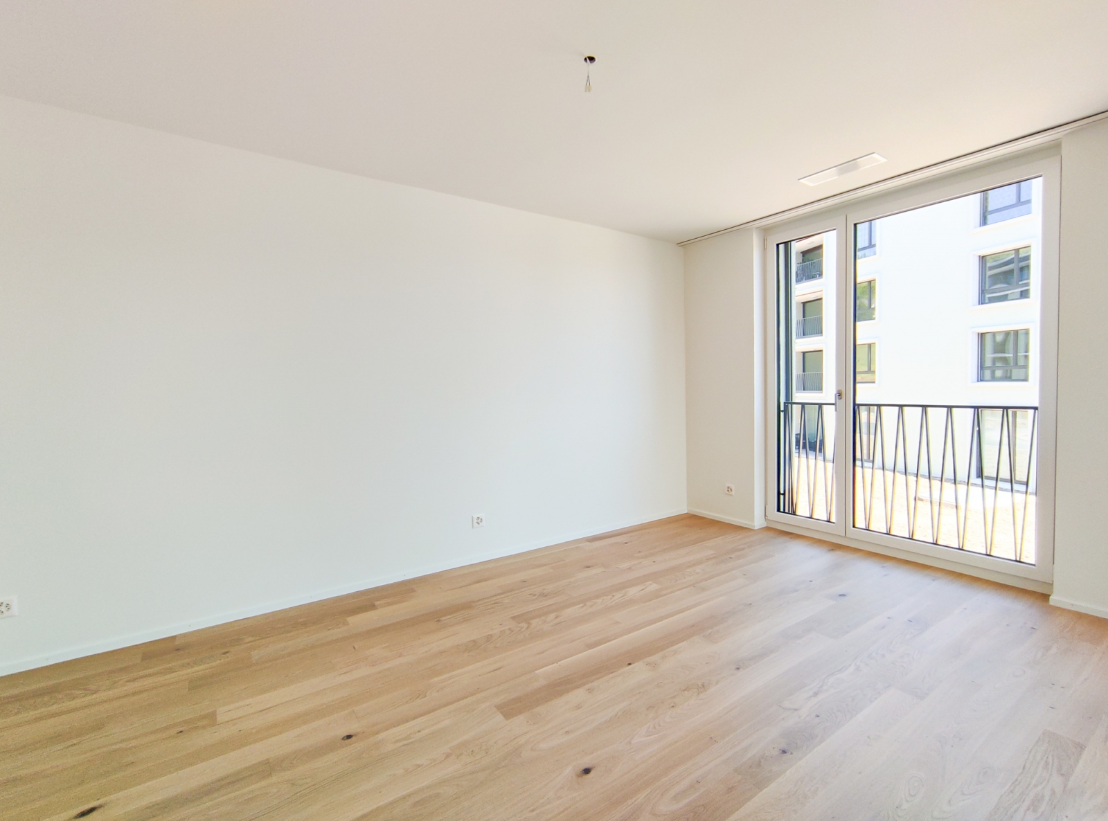 Helles, leeres Zimmer mit Balkonfenster