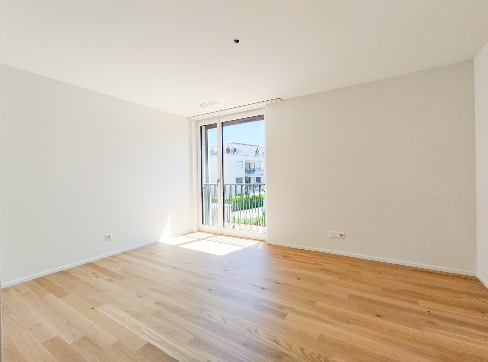 Helles, leeres Zimmer mit Balkonblick