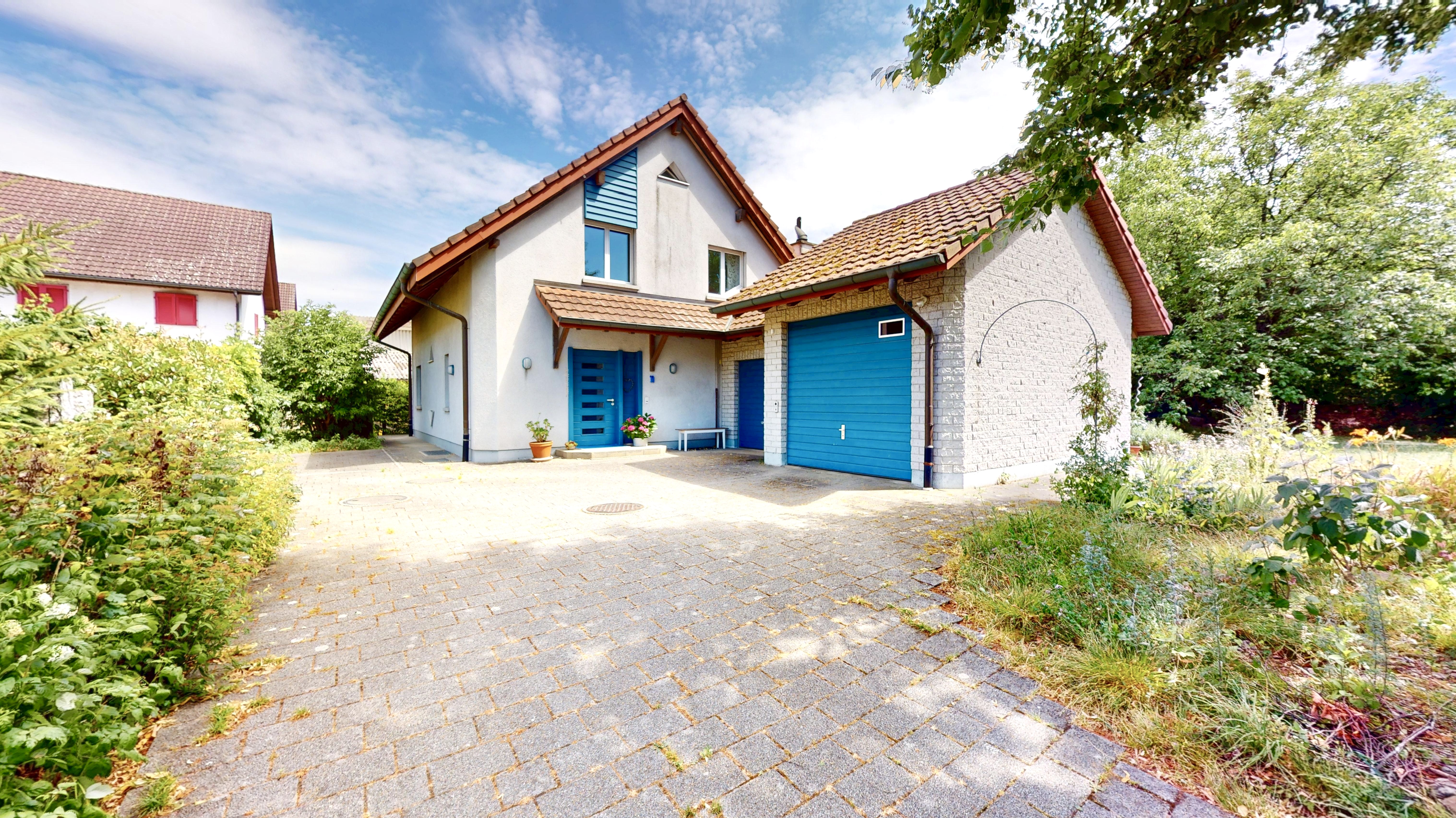 Außenansicht eines Einfamilienhauses mit Einfahrt