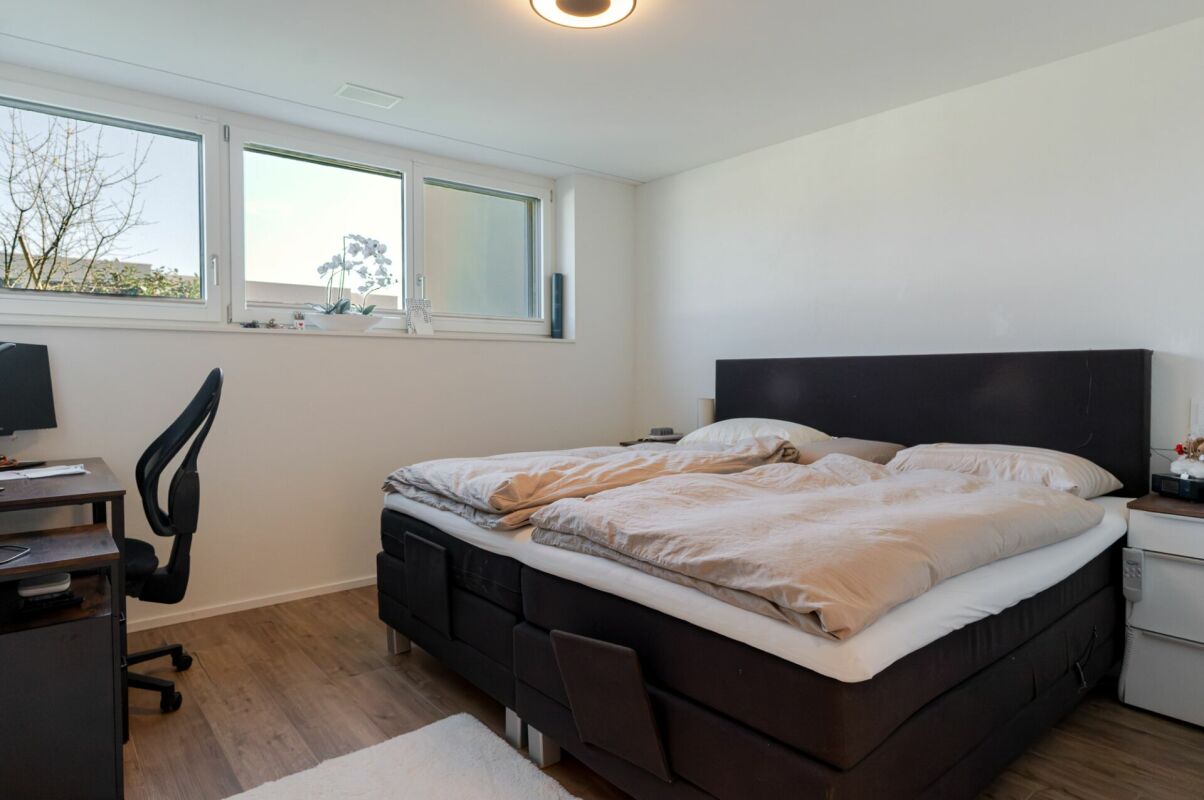 Schlafzimmer mit Doppelbett und Arbeitsplatz