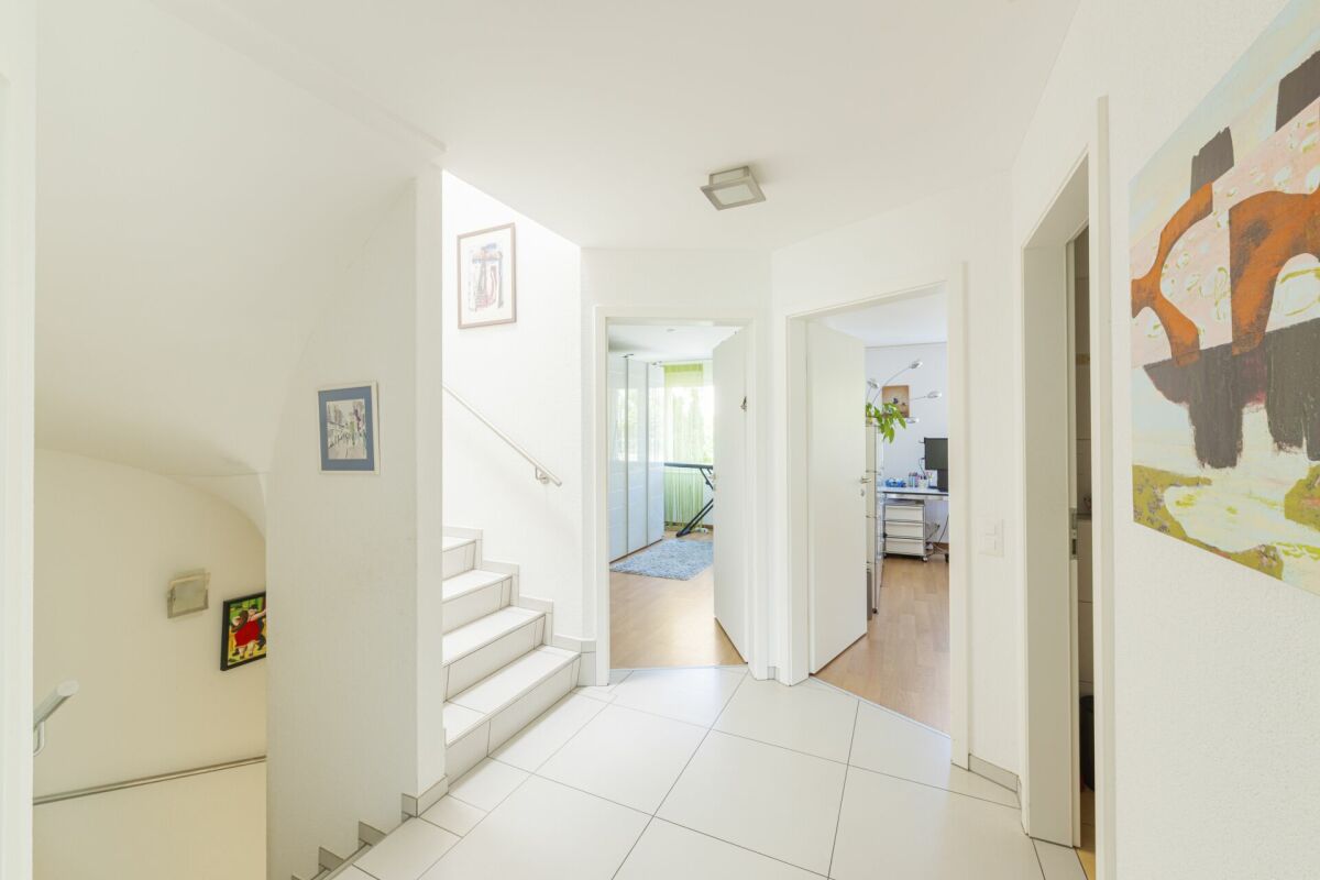 Heller Flur mit Treppe und geöffneten Türen