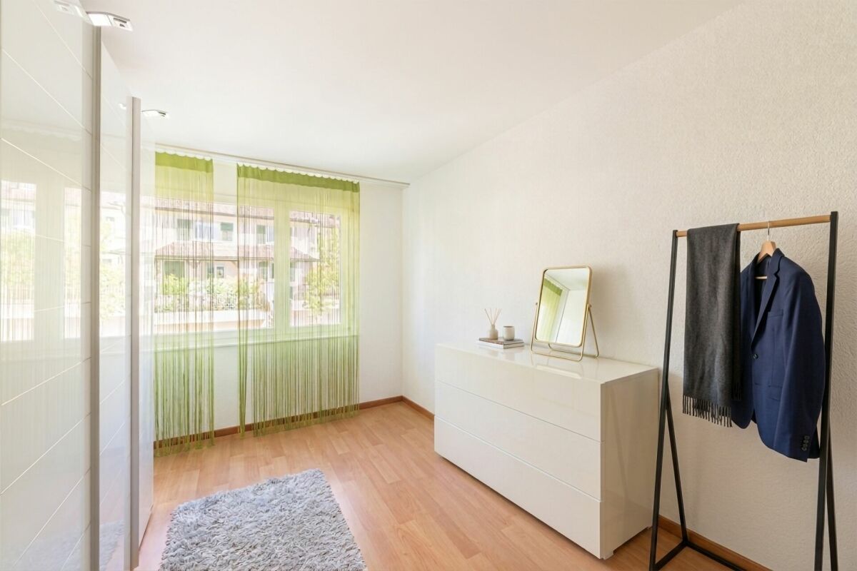 Heller Ankleide- bzw. Schlafzimmerbereich mit Fenster und Möbeln