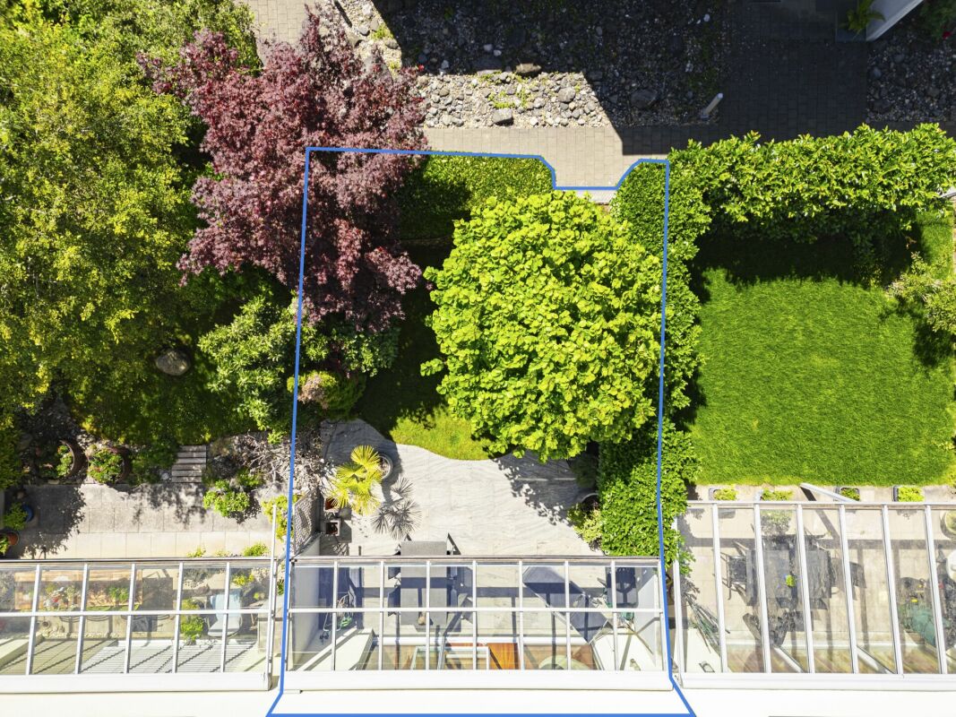 Drohnenblick auf einen grünen Garten mit Terrasse