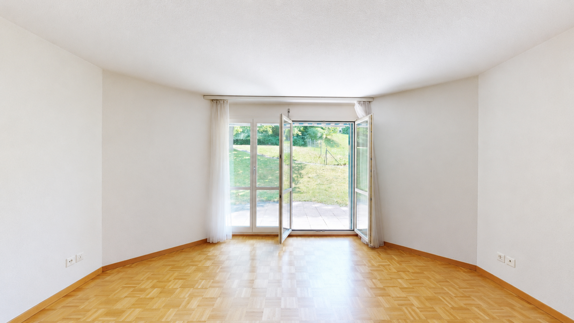 Leerer Wohnraum mit Gartenzugang