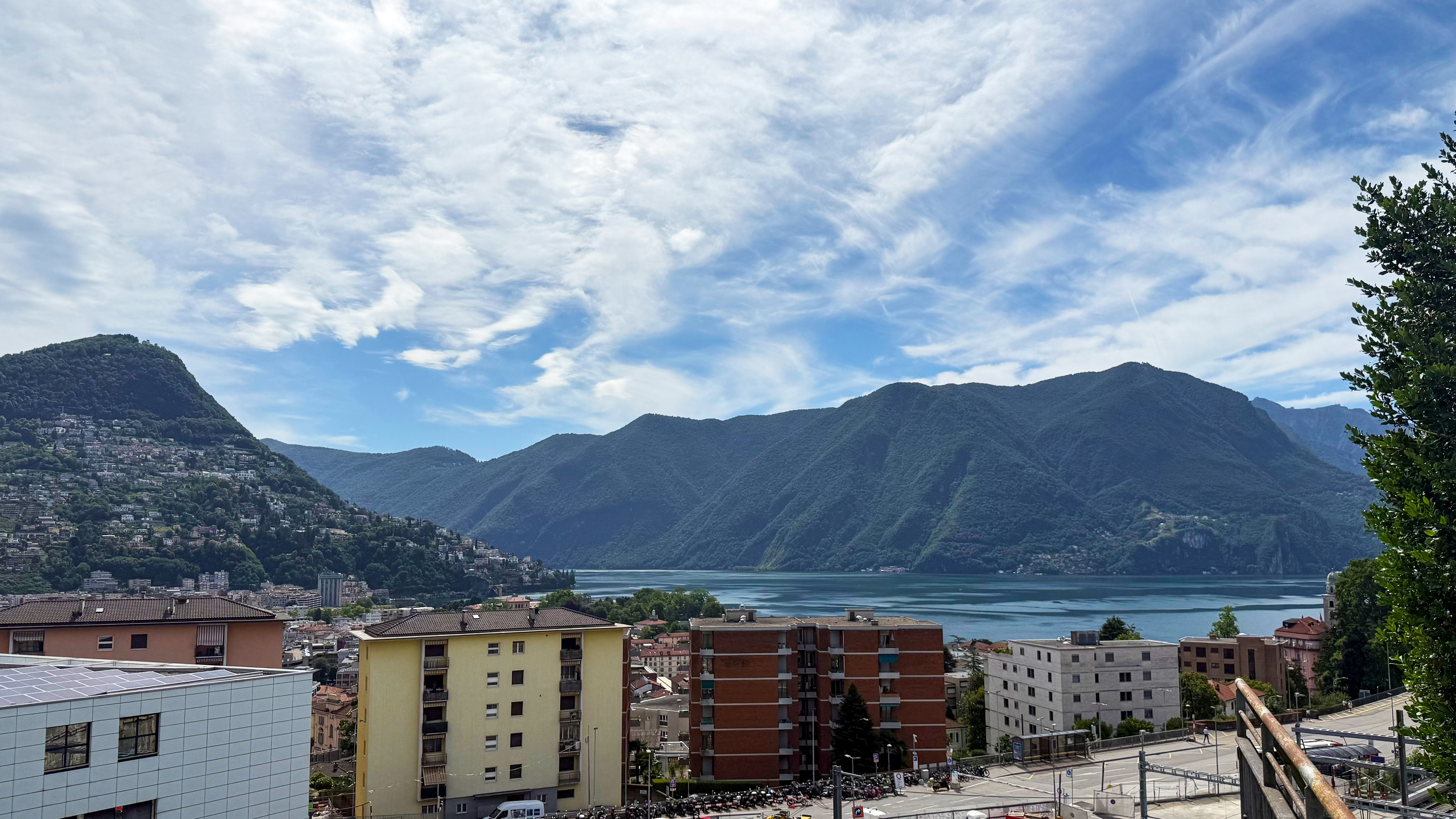 Seeblick mit Bergen und Stadtbebauung