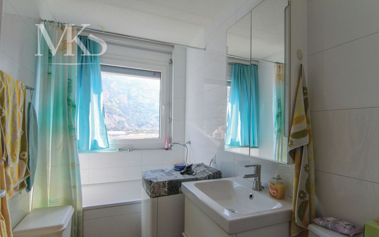 Helles Badezimmer mit Badewanne und Bergblick