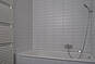 Badezimmerdetail mit Fliesenwand und Armatur