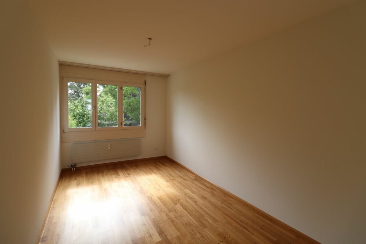 Leerer Wohnraum mit Fenster und Holzfußboden