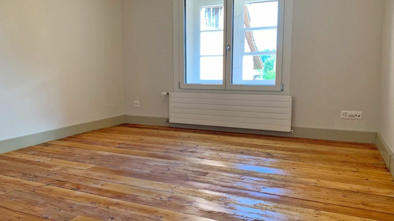 Leerer renovierter Raum mit Holzfußboden