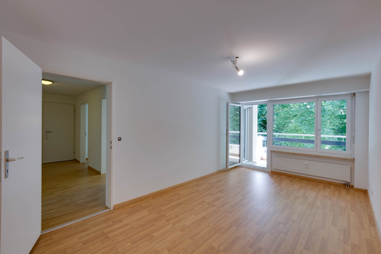 Helles, leerstehendes Zimmer mit Balkonblick