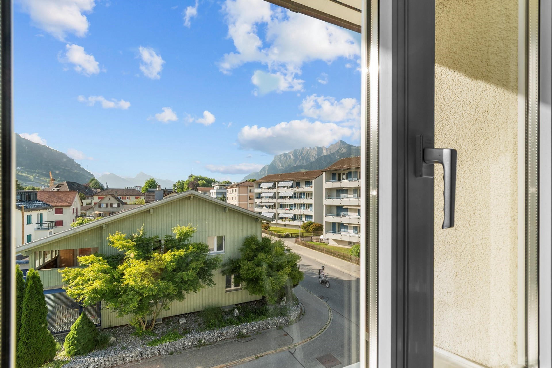 Blick aus dem Fenster auf Berge und Wohngebiet