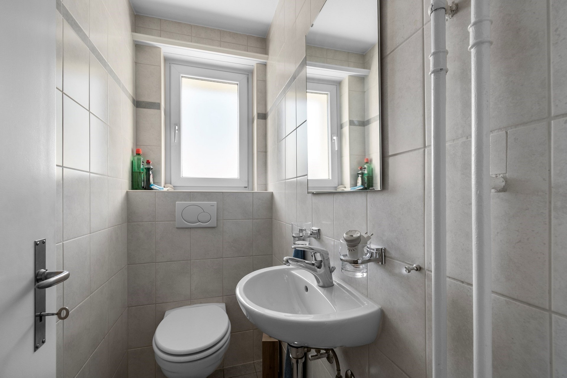 Kleines helles Gäste-WC mit Waschbecken und Fenster
