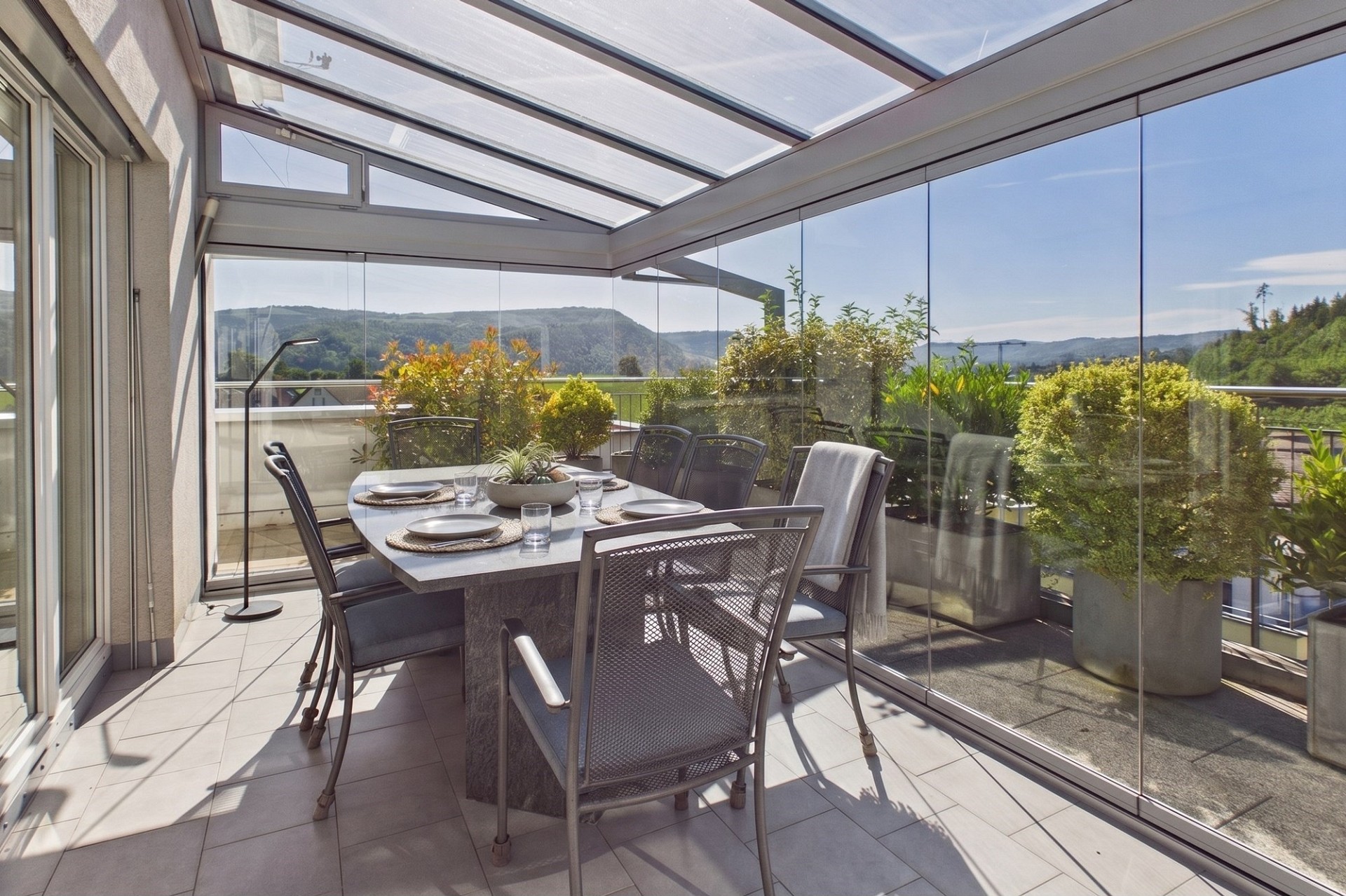 Verglaster Balkon mit Essbereich und Alpenblick