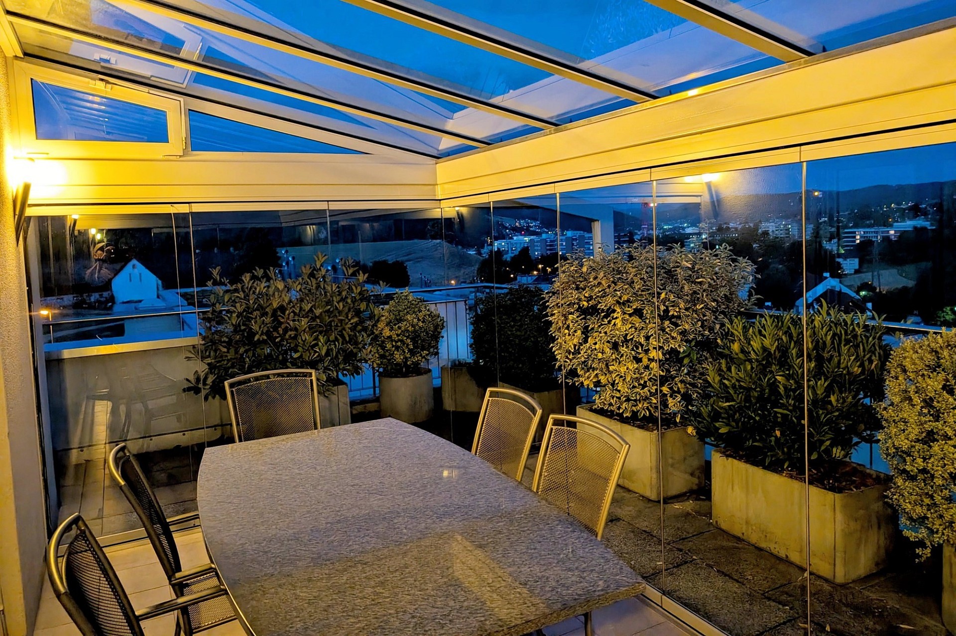 Überdachte Terrasse mit Blick über die Stadt bei Nacht