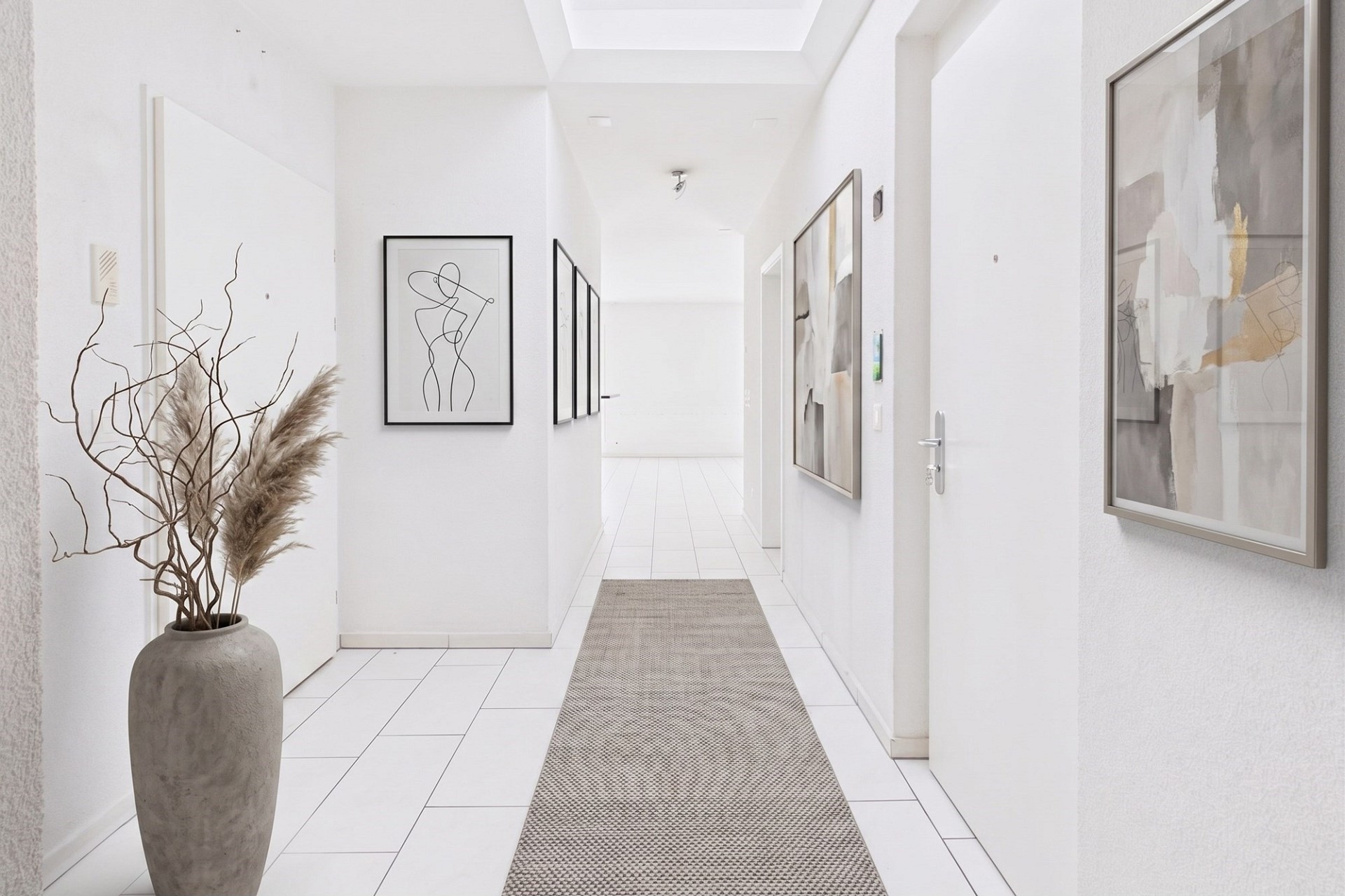 Heller, minimalistischer Flur mit Kunst und Teppichläufer