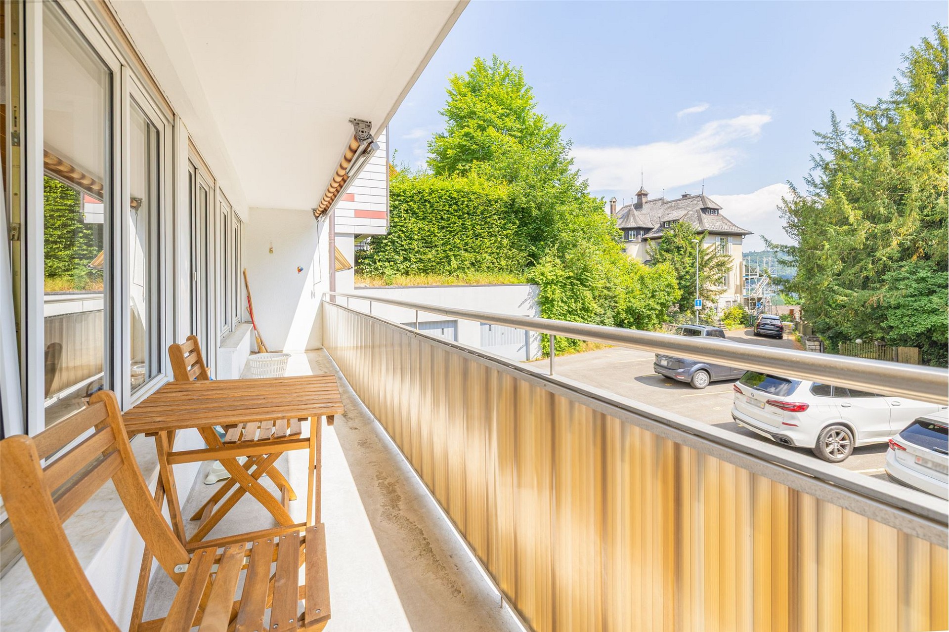 Balkon mit Holzstühlen und Straßenblick