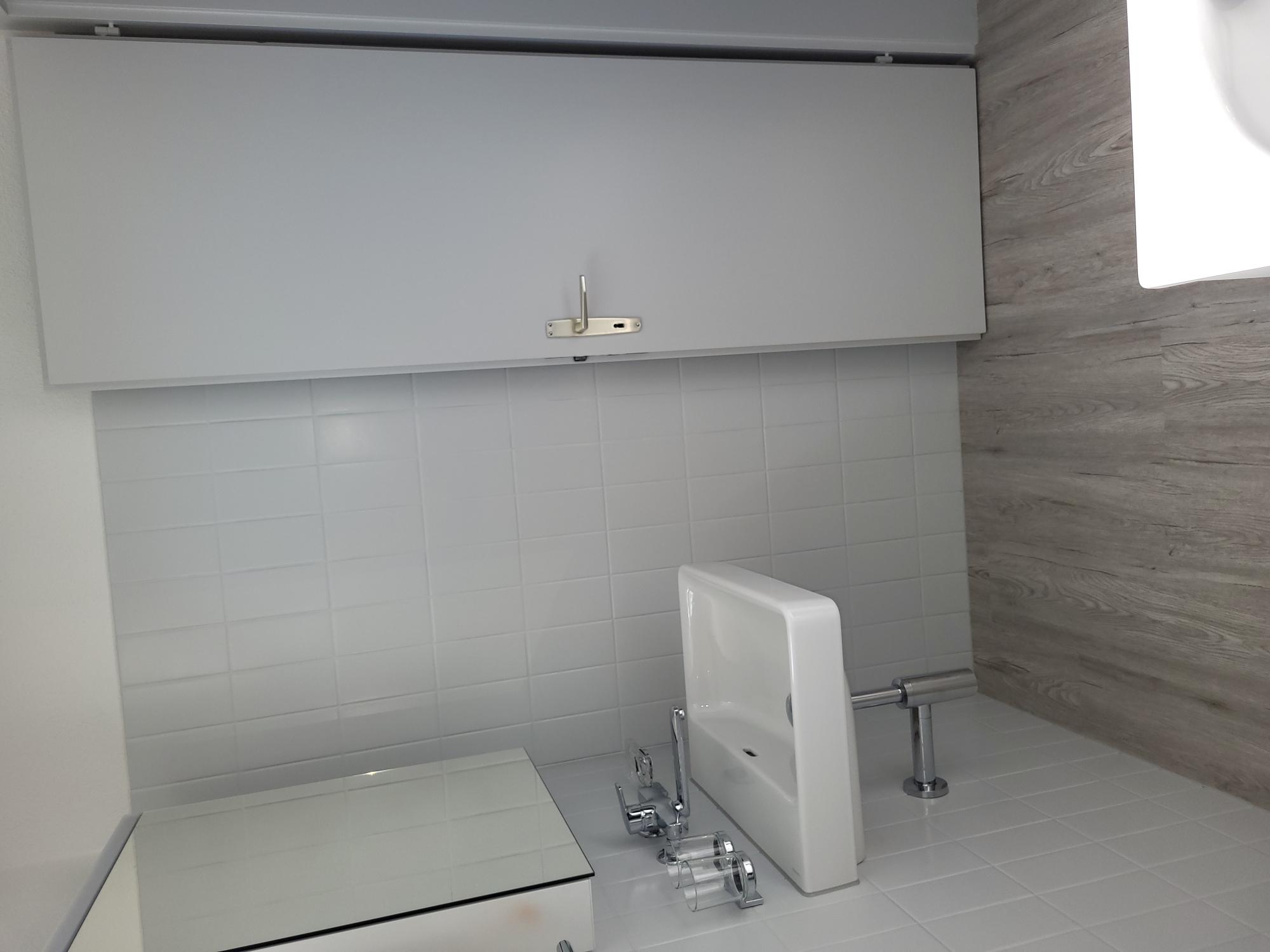 Kleines helles Badezimmer mit Waschtisch und Tür