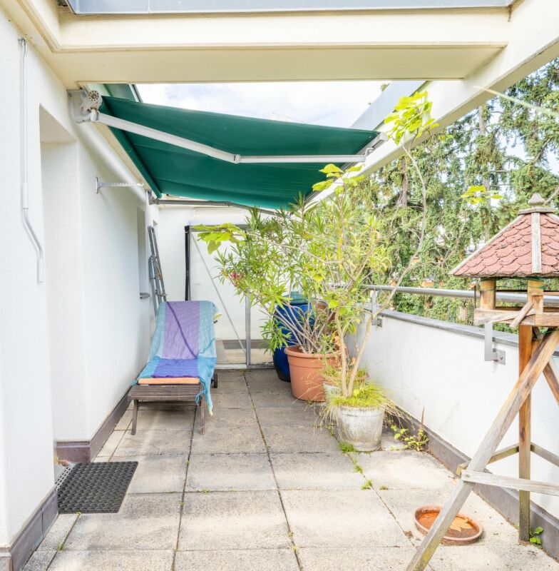 Balkon mit Markise und Pflanzen