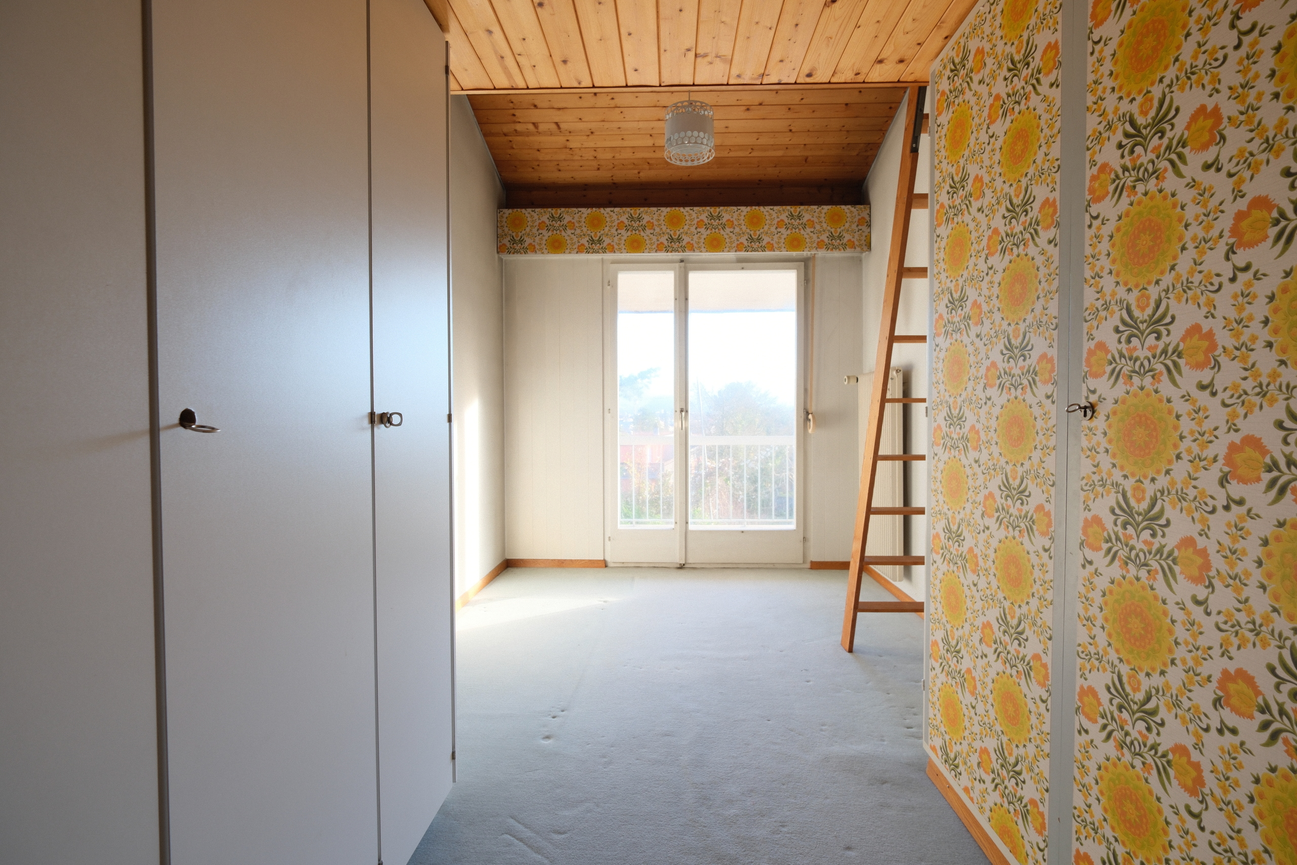 Helles Zimmer mit Holzdecke und Blümchentapete
