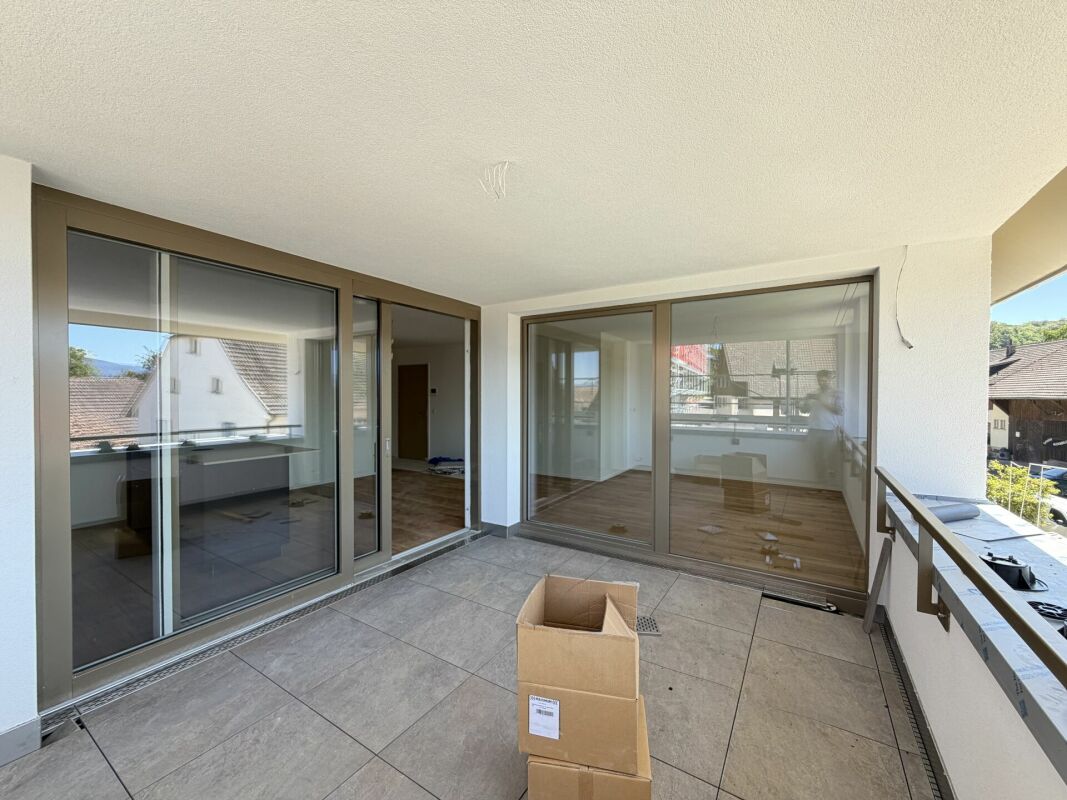 Überdachter Balkon mit großen Schiebetüren