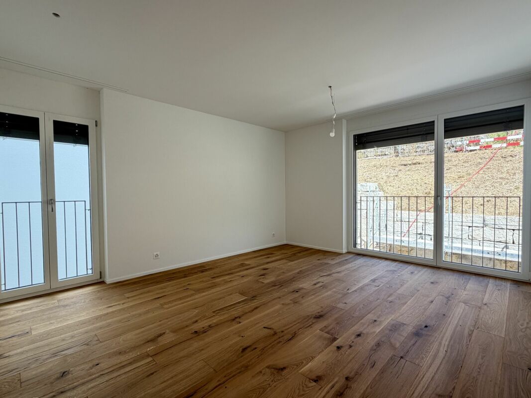 Leeres modernes Zimmer mit Holzparkett und großen Fenstern