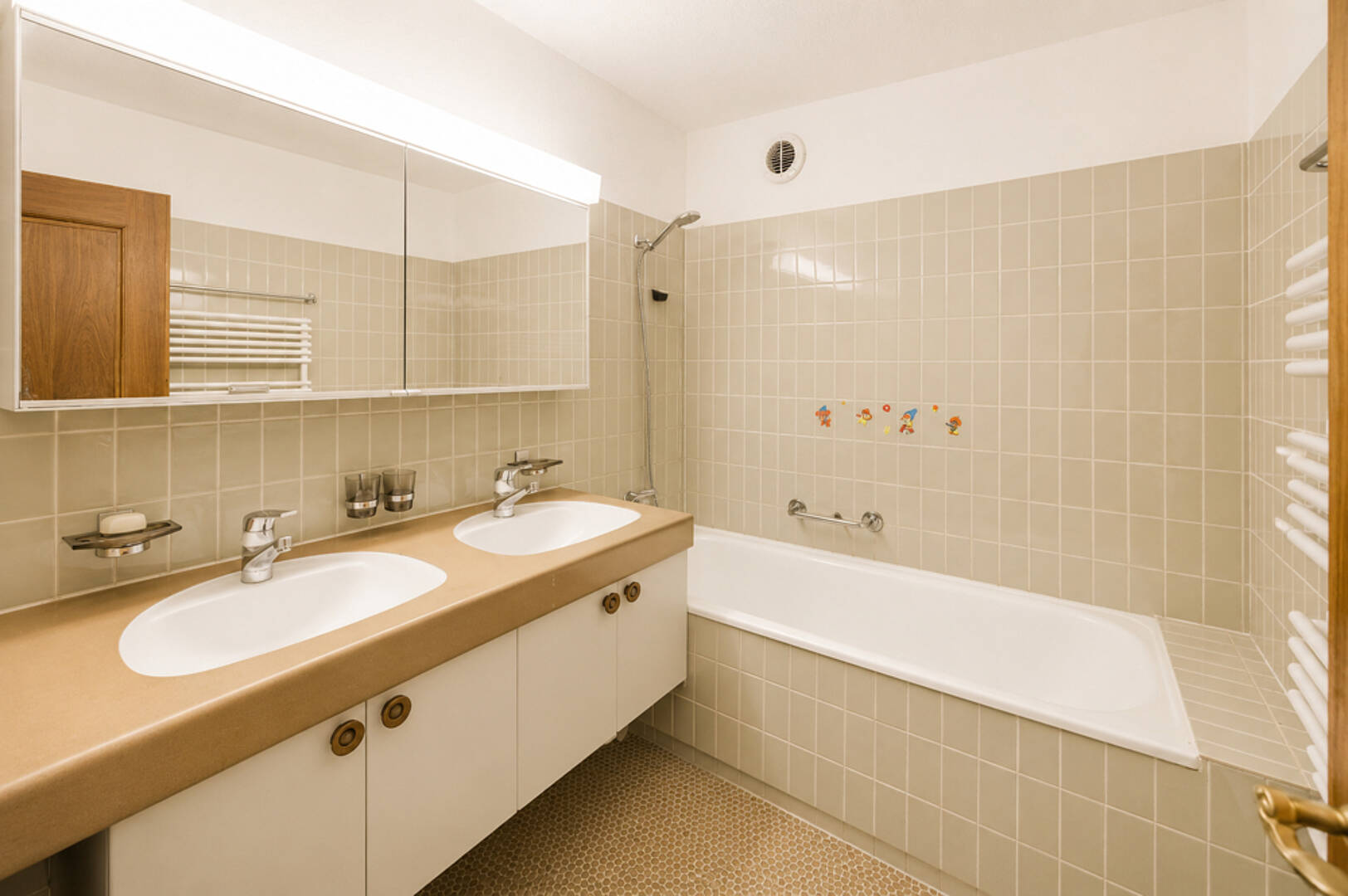 Helles Badezimmer mit Doppelwaschtisch und Badewanne