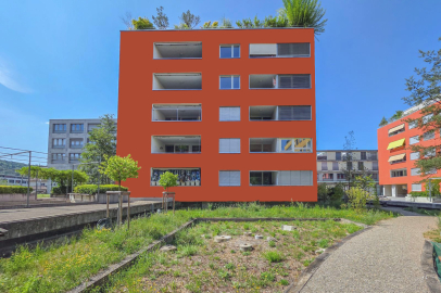 Mehrfamilienhaus mit auffälliger orangefarbener Fassade