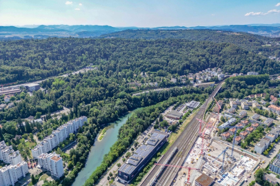 Luftaufnahme eines grünen Stadt- und Waldgebiets mit Flusslauf