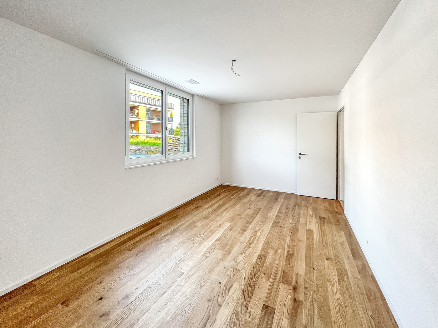 Leerer, hell renovierter Wohnraum mit Parkettboden