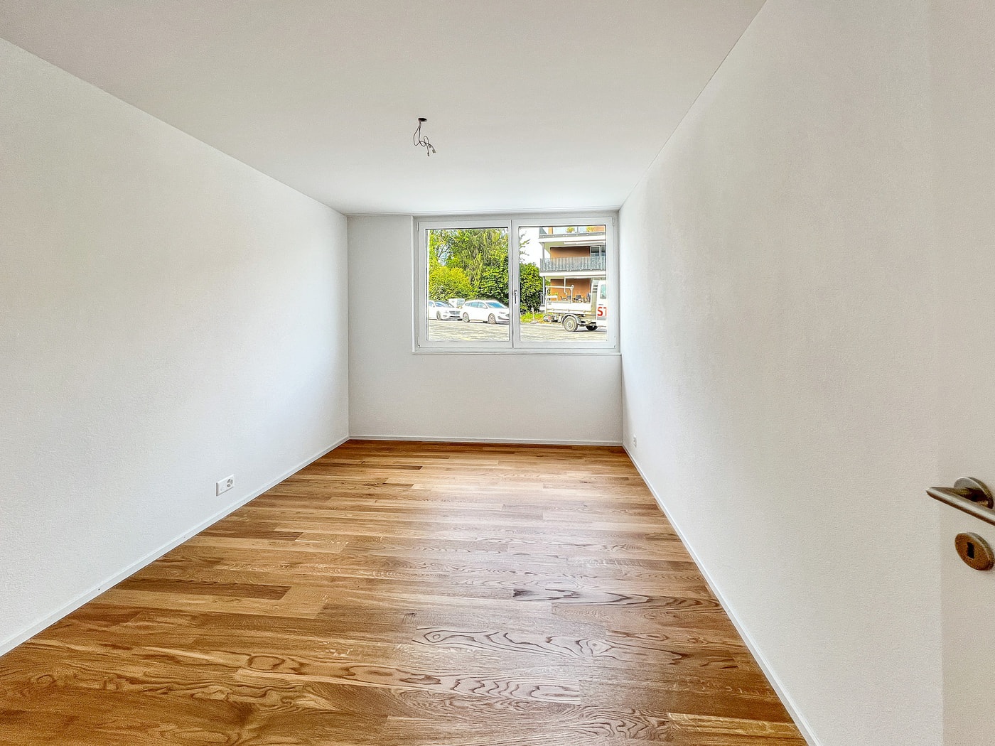Heller leerer Raum mit Holzfußboden und Fenster