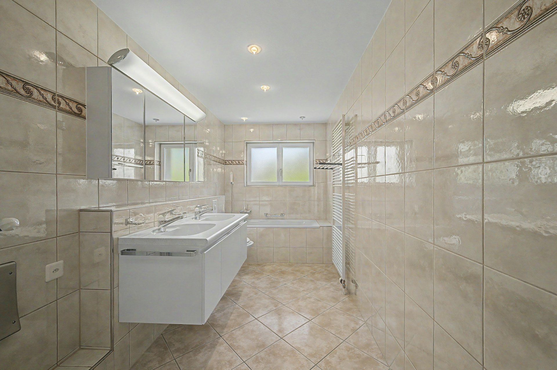Badezimmer mit Badewanne und Doppelwaschtisch