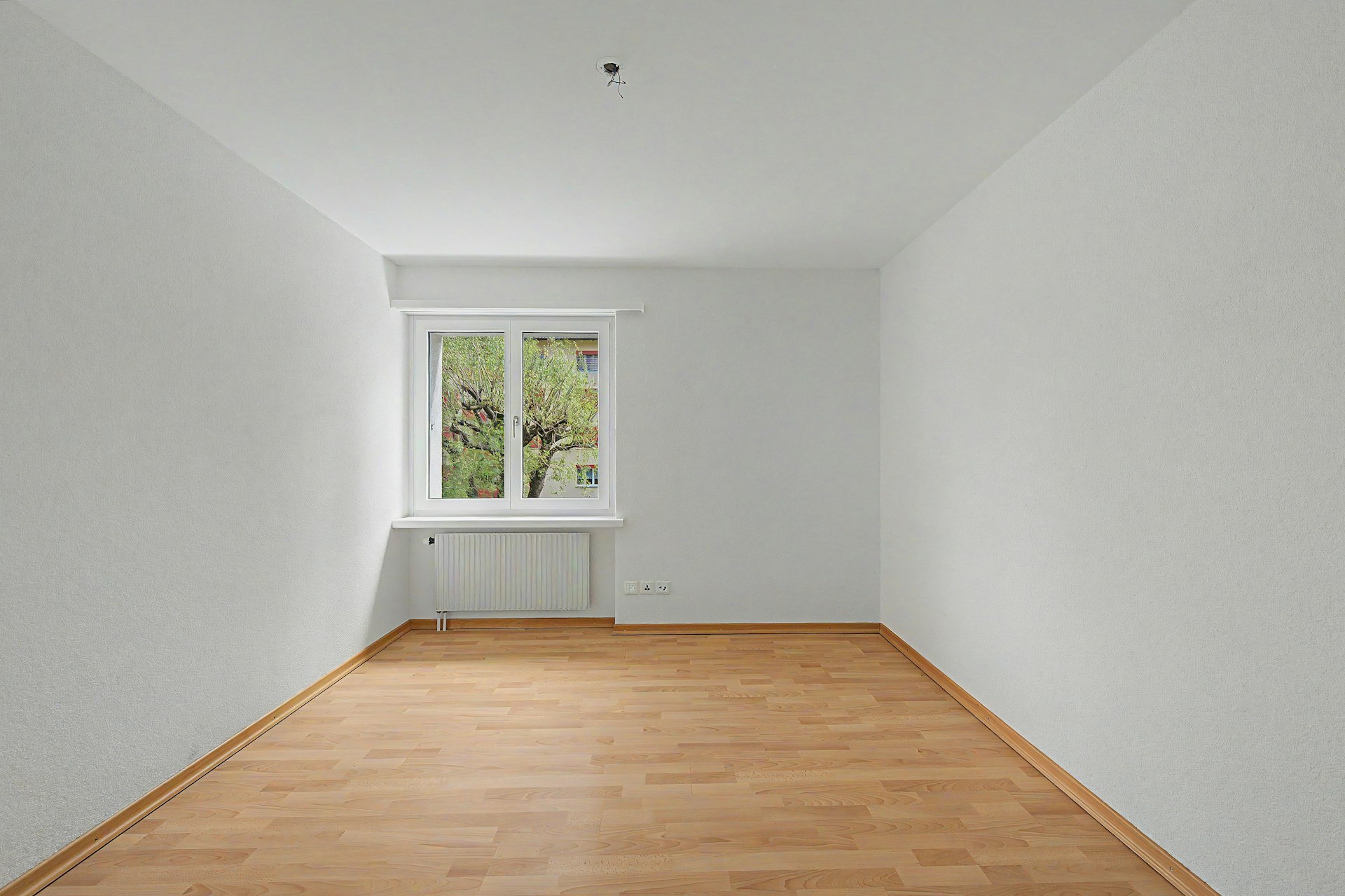 Leerer heller Raum mit Fenster und Heizkörper