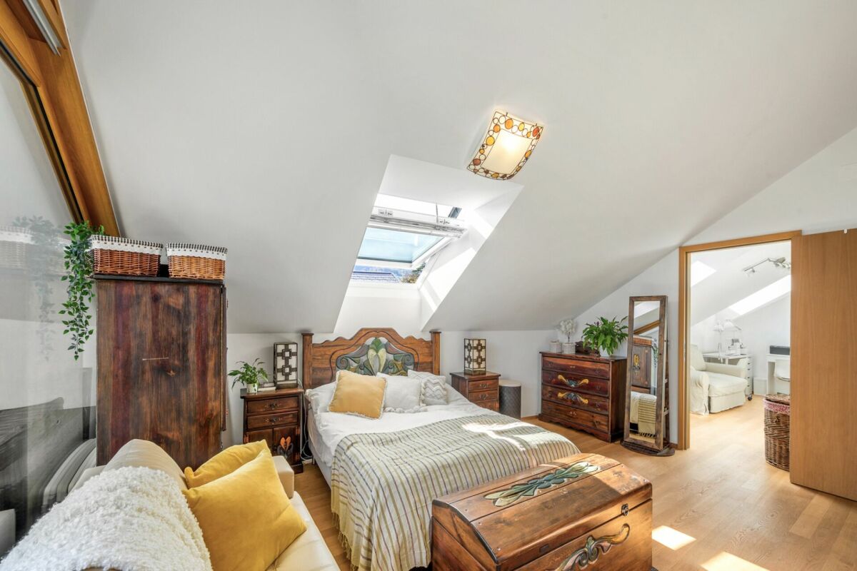 Dachgeschoss-Schlafzimmer mit rustikalen Holzmöbeln