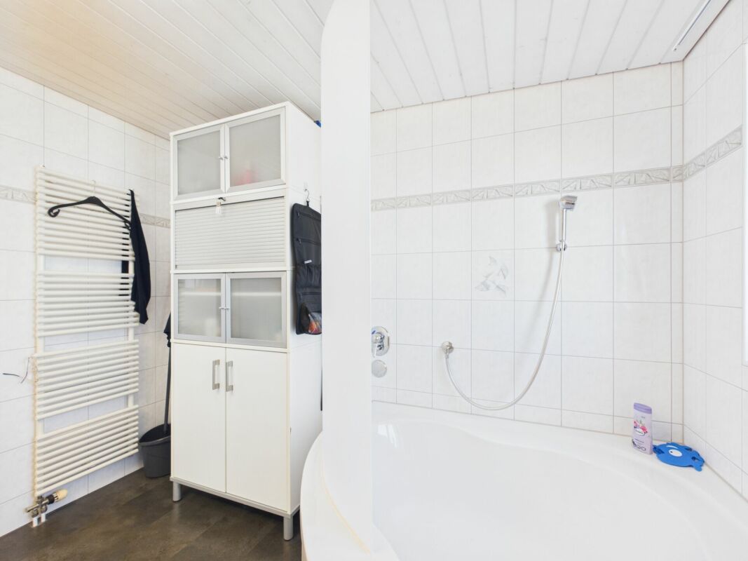 Modernes Badezimmer mit Badewanne und Aufbewahrungsschrank