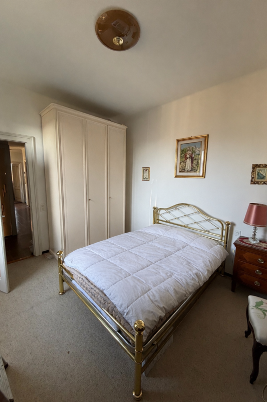 Schlafzimmer mit Messingbett und Kleiderschrank