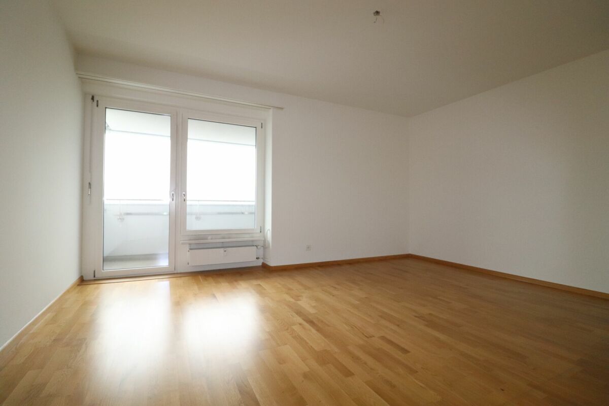 Leerer Wohnraum mit Balkonzugang