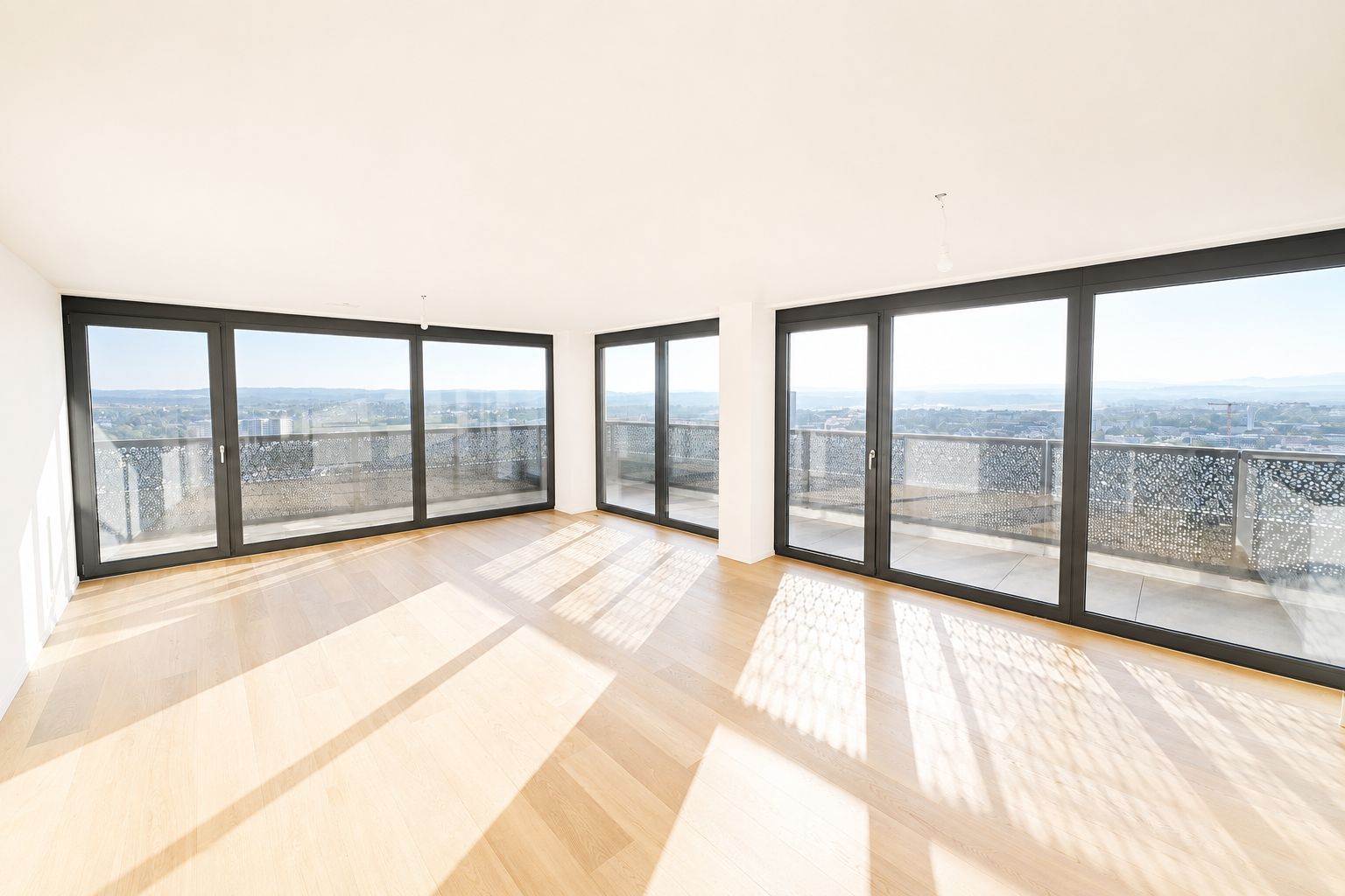 Heller leerer Wohnraum mit Panoramafenstern und Balkon