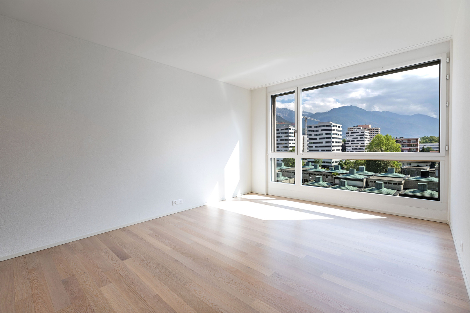 Heller leerer Raum mit Panoramafenster und Bergblick