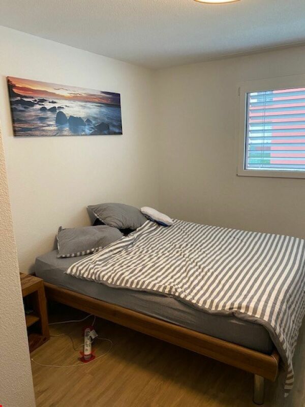 Kleines Schlafzimmer mit Bett und Fenster