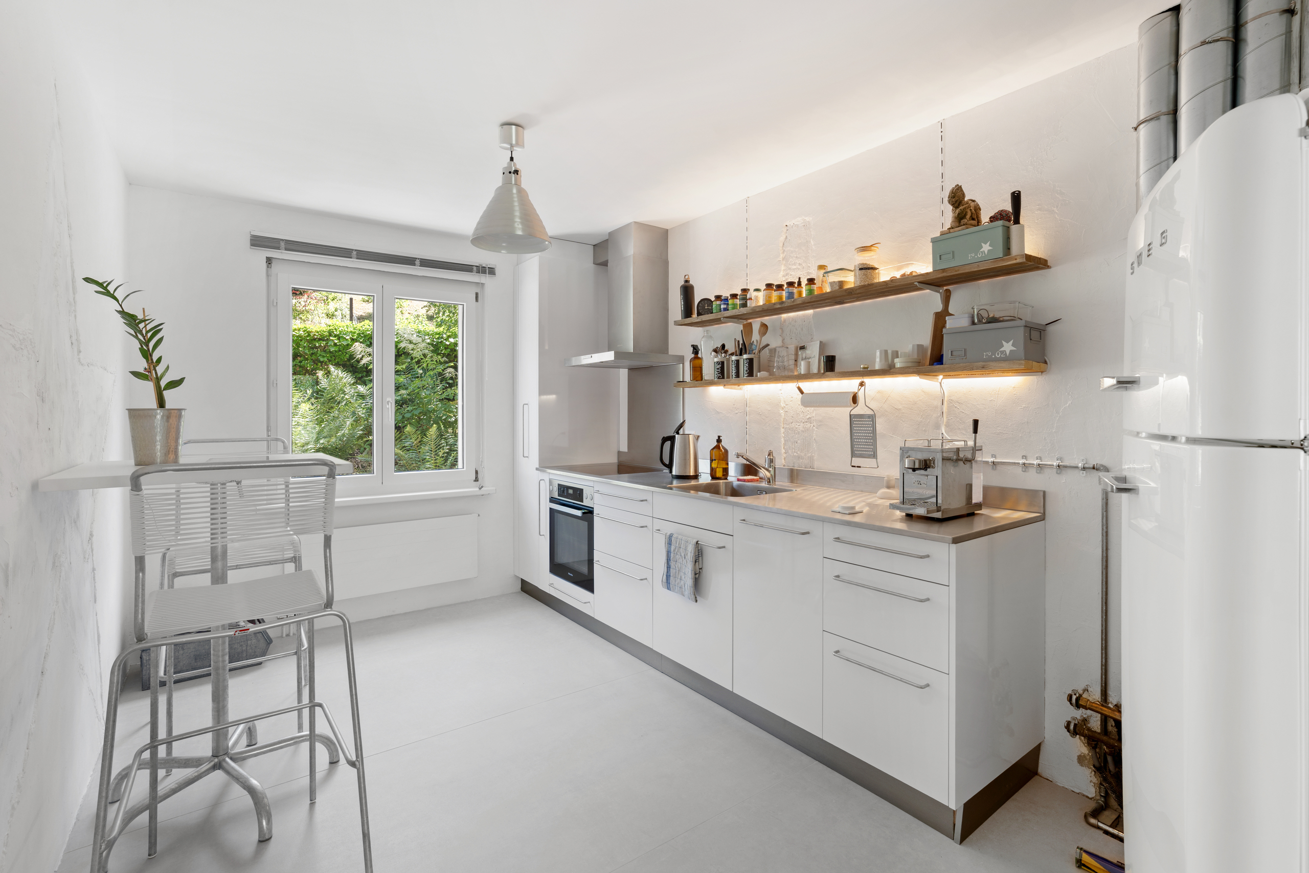 Helle, schmale Küche mit Fenster und offenen Regalen