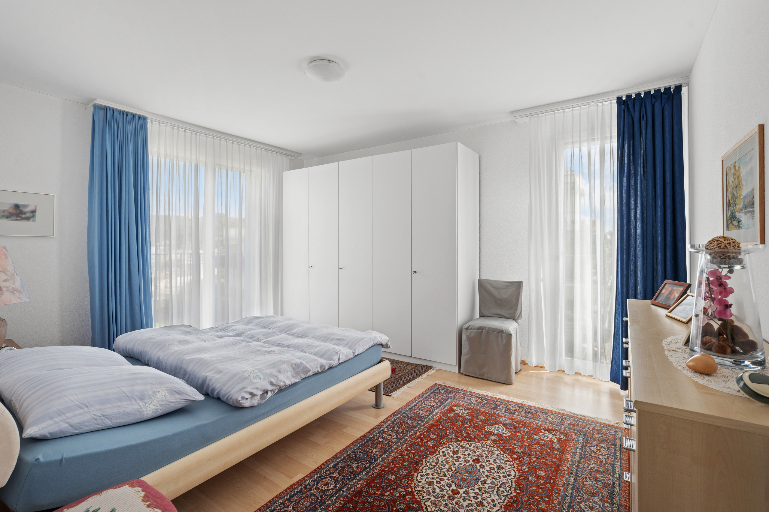 Helles Schlafzimmer mit Doppelbett und Kleiderschrank