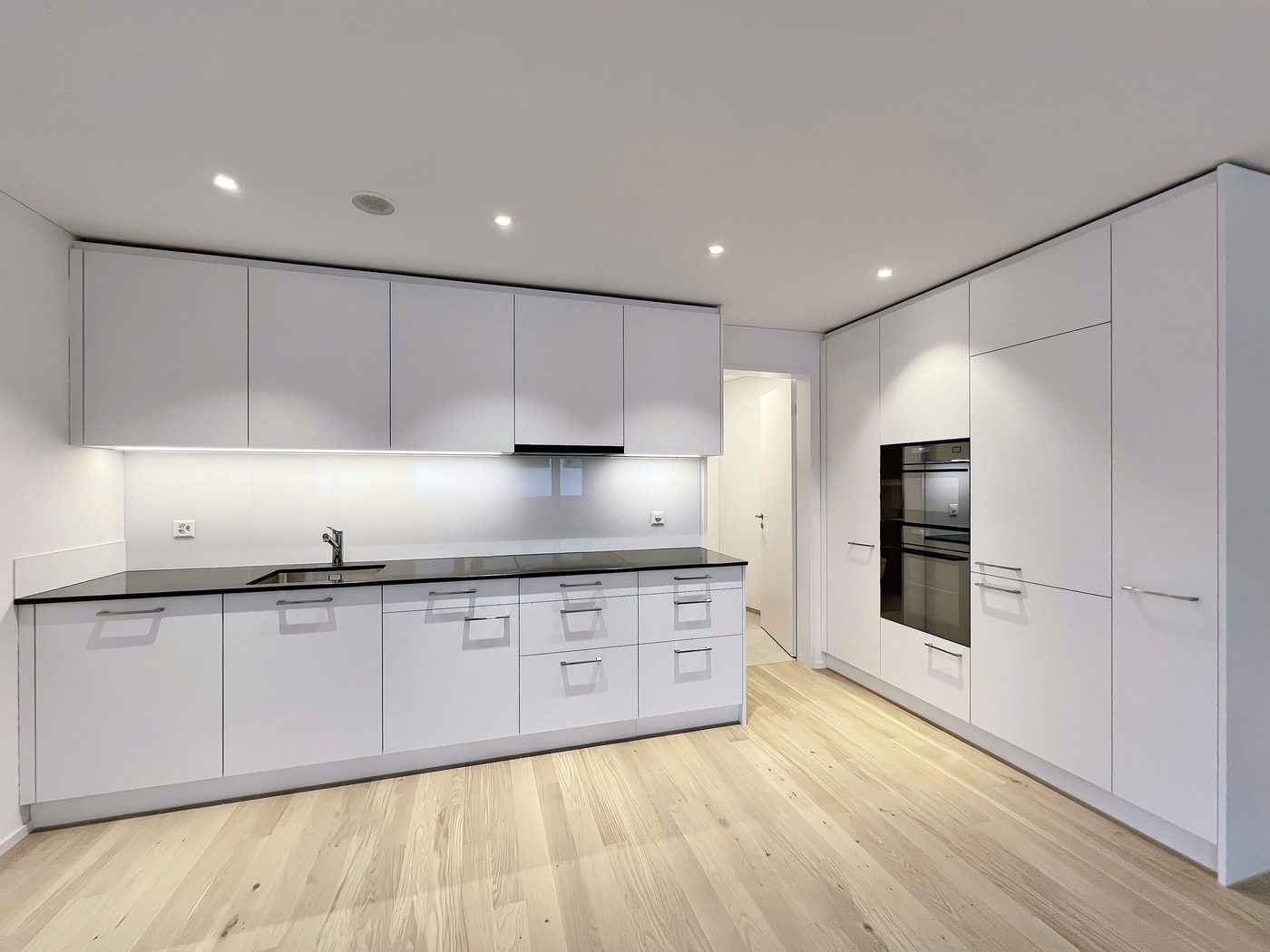 Moderne weiße Küche mit Einbaumöbeln